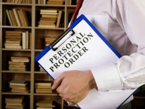 Man with clipboard and papers about Personal protection order PPO.